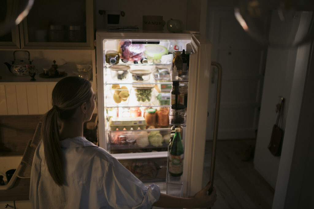 femme cherchant de la satisfaction alimentaire dans le réfrigérateur