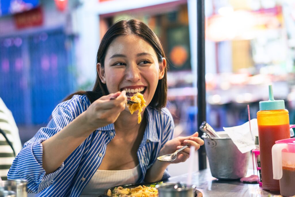 Femme mangeant des pâtes en étant heureuse et en bonne santé